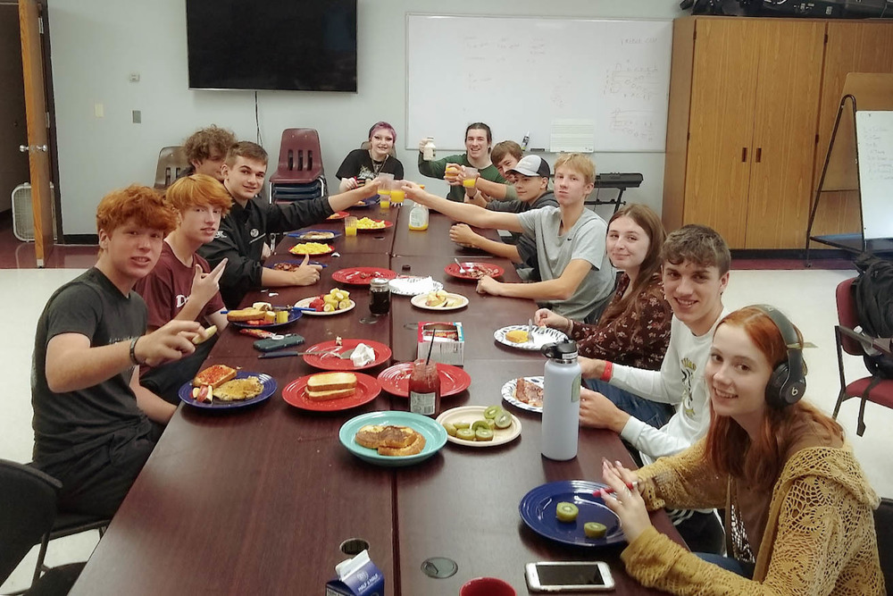 French World Language class sitting together at the table for their breakfast celebration